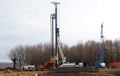 A tracked auger piling rig, a mobile crane and an excavator at the opening of new construction site