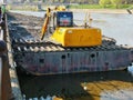 Tracked excavator dredging riverbed