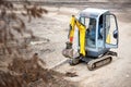 Tracked mini excavator breaks out old curbs before installing new curbs. The concept of using economical and compact equipment