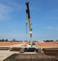 Tracked mobile telescopic crane in a large construction site, with steel cages in front