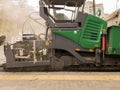 Tracked paver. Industrial pavement truck laying fresh asphalt on construction site. Asphalt a new on the road texture and a Royalty Free Stock Photo
