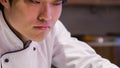 Tracking shot of smiling Asian chef giving last