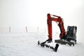 Tracklaying excavator at top of snow mountain Royalty Free Stock Photo