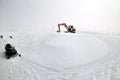 Tracklaying excavator at top of snow mountain Royalty Free Stock Photo