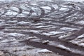 Tracks of car tires on melting snow on asphalt of the road Royalty Free Stock Photo