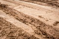 Tracks of car tires on a wet, swampy road with brown water. Country dirt road with paddles after rain Royalty Free Stock Photo