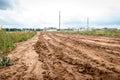 Tracks of car tires on a wet, swampy road with brown water. Country dirt road with paddles after rain