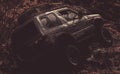 Tracks on a muddy field. Bottom view to big offroad car wheel on country road and mountains backdrop. Off-road vehicle Royalty Free Stock Photo