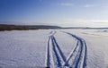Tracks on the river ice from a snowmobile Royalty Free Stock Photo