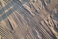 Tracks in sand. Part of prints and tracks of tire, foot, feet, sun sea slippers in beach sand. Royalty Free Stock Photo