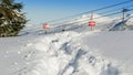 Tracks in the snow beside a ski area boundary sign. Royalty Free Stock Photo