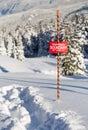 Tracks in the snow beside a ski area boundary sign. Royalty Free Stock Photo