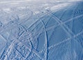 Tracks of a snowcat and skiers on a snowy surface. The stripes form an amazing snowy texture