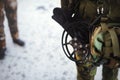 Traction ice cleats anti-slip microspikes hanging at the waist of a man in military clothes.