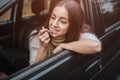 Tractive woman apply pink lipstick in front of rearview mirror in car. Close up Hand. Autumn concept. Autumn forest Royalty Free Stock Photo