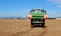 Tractor with an agricultural sprayer machine, spreads fertilizer on freshly plowed field in first spring Royalty Free Stock Photo