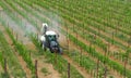 Tractor with agricultural sprayer machine sprinkls chemical pesticides on the vineyards. Top view