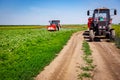 Tractor as spraying field of sunflower, as waving in wind, with sprayer, herbicide and pesticide