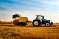 Tractor with bale machine for harvesting straw in the field and making large round bales. Agricultural work, harvesting Royalty Free Stock Photo