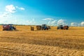 Tractor with bale machine for harvesting straw in the field and making large round bales. Agricultural work, harvesting Royalty Free Stock Photo