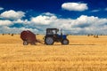 Tractor with bale machine for harvesting straw in the field and making large round bales. Agricultural work, harvesting Royalty Free Stock Photo