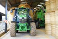 Tractor and barley straw bales stacked in barn