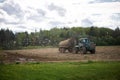 Tractor with a barrel of fertilizer in field. Agricultural equipment and industrial work Royalty Free Stock Photo