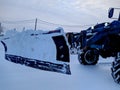 tractor with a bucket for cleaning snow in the daytime in winter. Royalty Free Stock Photo