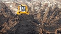 Tractor bulldozer removes top layer of fertile soil overburden forest, grass, harvesting site for open mine. Concept Royalty Free Stock Photo