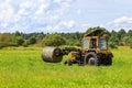 Tractor carrying a bale of hay across the field Royalty Free Stock Photo