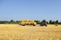 Tractor carrying hay bale rolls - stacking them on pile. Agricultural machine collecting bales of hay on a field Royalty Free Stock Photo