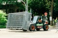 Tractor carrying metallic fence on urban street