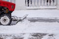 Tractor cleaning snow at city street and a parking lot after snowfall Royalty Free Stock Photo