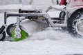 Tractor cleaning snow at city street and a parking lot after snowfall Royalty Free Stock Photo