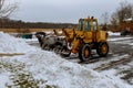 Tractor cleaning snow at city street and a parking lot after snowfall Royalty Free Stock Photo