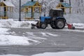 Tractor is sweeping snow in snowfall