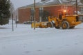 Tractor cleaning snow at street and a parking lot after snowfall Royalty Free Stock Photo