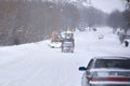 A tractor cleans snow on the road during a blizzard in winter