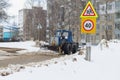 Tractor clears snow with a bucket in winter on the road with a bucket Royalty Free Stock Photo