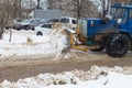 Tractor clears snow with a bucket in winter on the road with a bucket Royalty Free Stock Photo