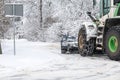 Tractor clears snow from road after snowfall, chains on tractor wheel, winter landscape Royalty Free Stock Photo
