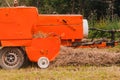 The tractor collects dry hay in the field, the hay presses the bale press, work in the field Royalty Free Stock Photo