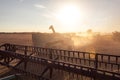 Tractor and combine harvester on a field during sunset