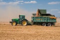 Tractor and combine John Deere on harvested field