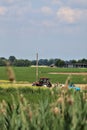 Tractor in a cultivated field in the italian countryside in summer Royalty Free Stock Photo