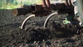 The tractor cultivates and cuts furrows in the field. Tractor work in the black soil field in the village