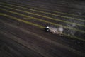 Tractor cultivating field at spring, aerial view