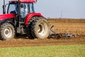 Tractor cultivating field at spring