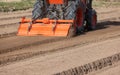 Tractor cultivating land with a rotary tiller in farm