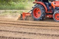 Tractor cultivating land with a rotary tiller in farm